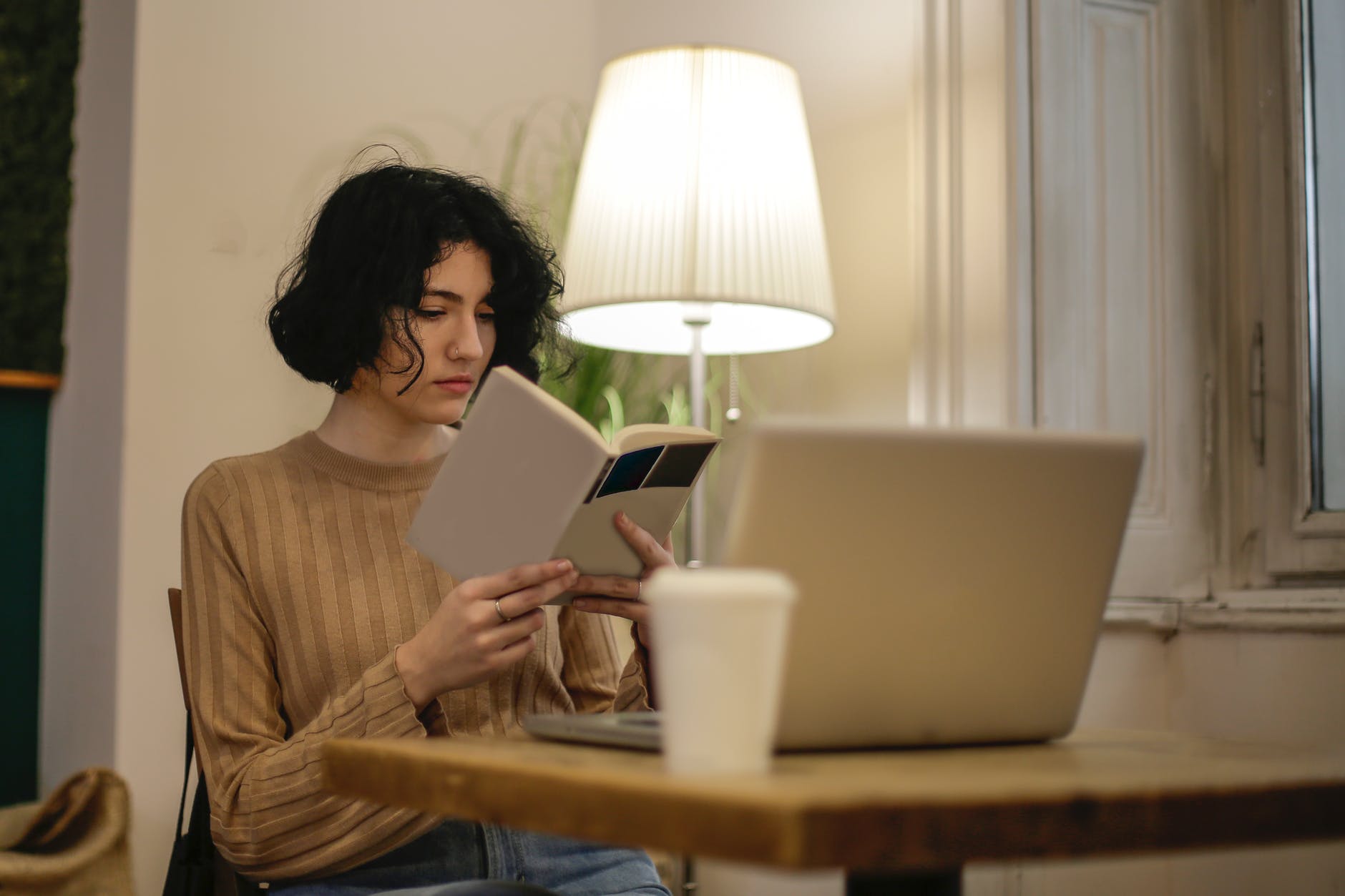 woman in brown long sleeve shirt holding a book